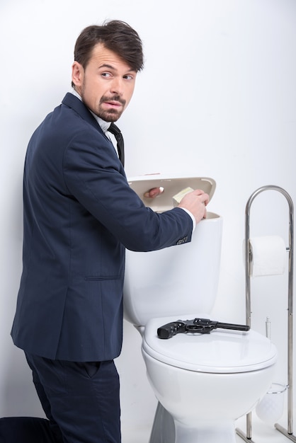 Młody Biznesmen Ukrywa Pieniądze W Zbiorniku Toalety.