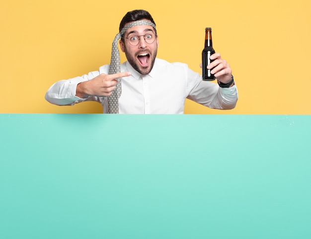 Młody biznesmen z butelką piwa świętuje dobre wieści