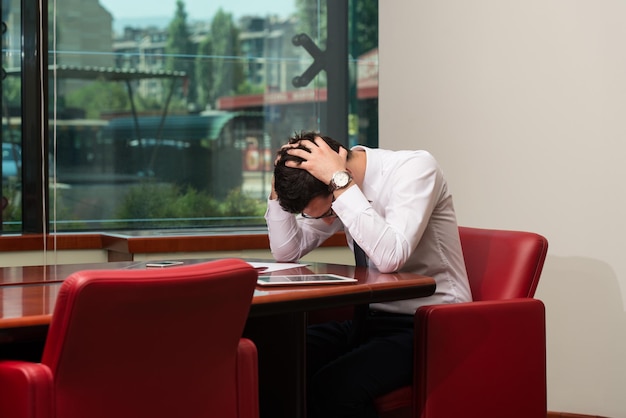 Młody biznesmen z problemami i stresem w biurze