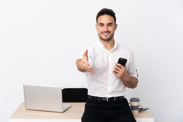 Młody biznesmen z telefonu komórkowego w miejscu pracy uzgadniania po dobrej ofercie