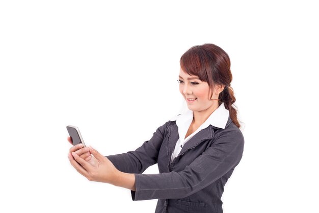 Młody biznesowej kobiety mienia telefon komórkowy na białym tle
