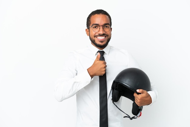 Młody biznesowy łaciński mężczyzna z kaskiem motocyklowym na białym tle dający gest kciuka w górę