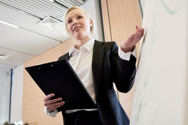 Zdjęcie młody bizneswoman przedstawia projekt przy whiteboard