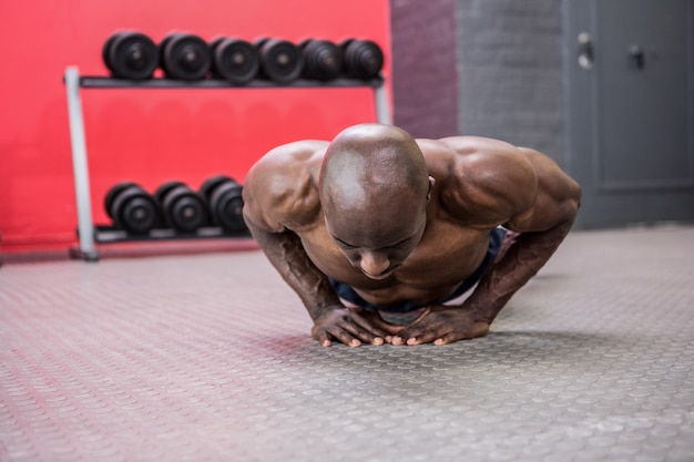 Młody bodybuilder robi ćwiczeniom w crossfit gym