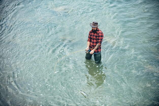 Młody Brodaty Mężczyzna łowiący Ryby W Jeziorze Lub Rzece Flyfishing