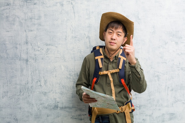 Młody chiński badacza mężczyzna trzyma mapę pokazuje liczbę jeden