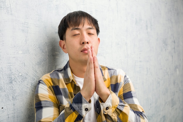 Młody chiński mężczyzna twarzy zbliżenie ono modli się bardzo szczęśliwy i ufny