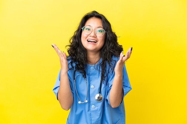 Młody chirurg lekarz azjatycka kobieta na białym tle na żółtym tle z niespodzianką wyrazem twarzy