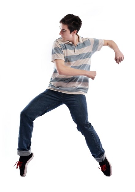 młody chłopak mężczyzna nastolatek tańczy i skacze na białym tle w studio