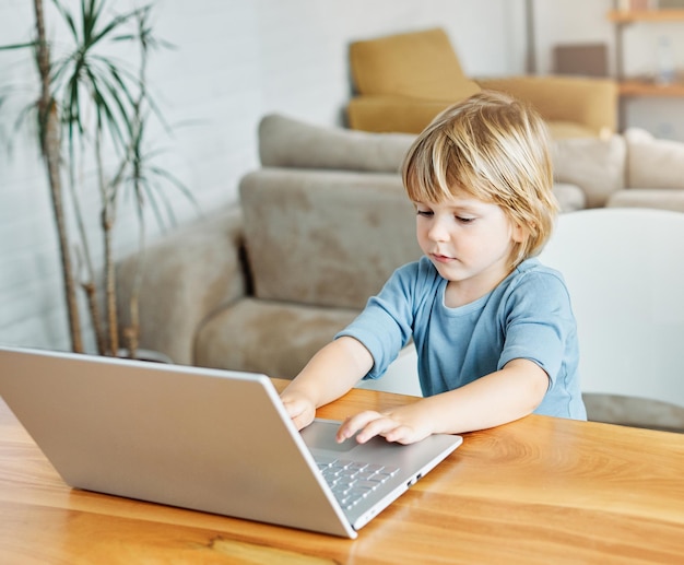 Zdjęcie młody chłopak robi pracy na laptopie w domu