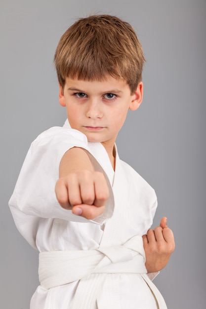 Młody chłopak ubrany w białe kimono karate