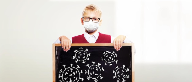 Młody chłopak z maską ochronną przed wirusem koronowym w szkole