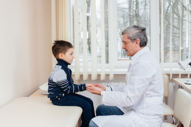 Młody chłopiec jest słuchany i leczony przez doświadczonego lekarza w nowoczesnej klinice. Wirus i epidemia