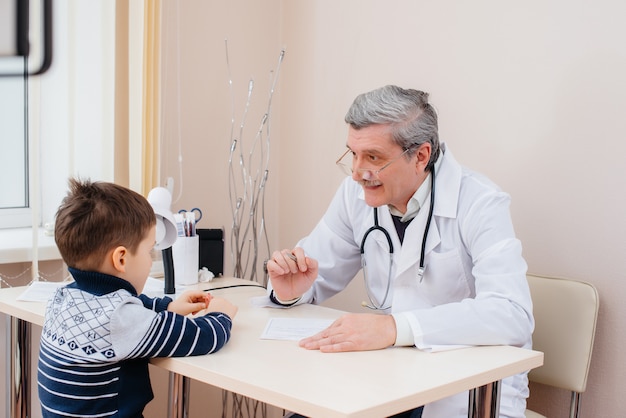 Młody Chłopiec Jest Słuchany I Leczony Przez Doświadczonego Lekarza W Nowoczesnej Klinice. Wirus I Epidemia.