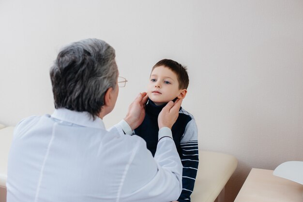 Młody chłopiec jest słuchany i leczony przez doświadczonego lekarza w nowoczesnej klinice. Wirus i epidemia.