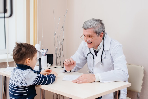 Młody chłopiec jest słuchany i leczony przez doświadczonego lekarza w nowoczesnej klinice. Wirus i epidemia.