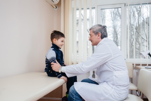 Młody chłopiec jest słuchany i leczony przez doświadczonego lekarza w nowoczesnej klinice. Wirus i epidemia.