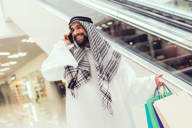 Młody Człowiek Arabian Przy Użyciu Telefonu Komórkowego W Nowoczesnym Centrum Handlowym.