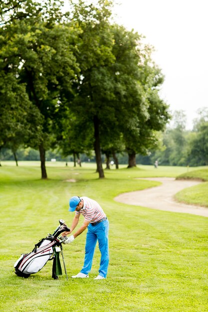 Młody człowiek bawić się golfa przy golfowym sądem