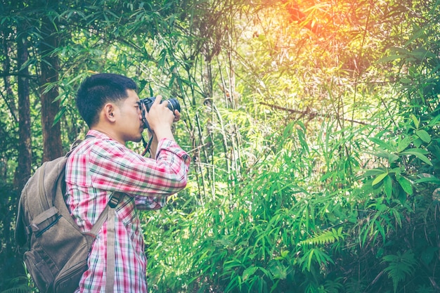 Młody człowiek bierze fotografie w dzikim z dslr kamerą