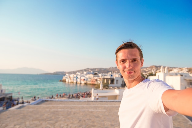 Młody człowiek bierze selfie portret w Małej Wenecja w Mykonos