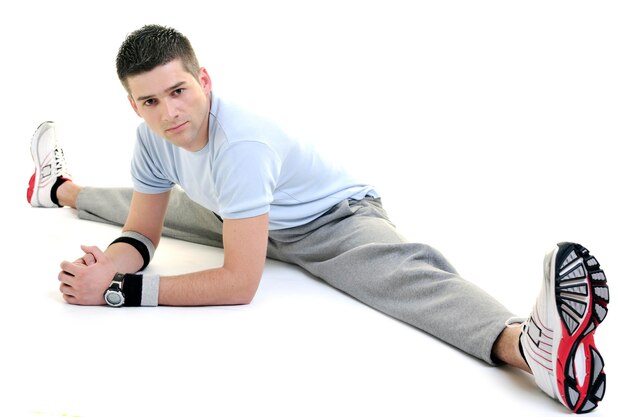 młody człowiek ćwiczy fitness sport i strech na białym tle w studio
