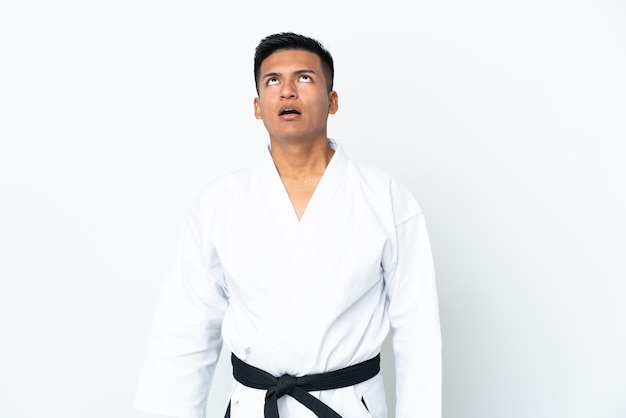 Młody człowiek Ekwadoru robi karate na białym tle