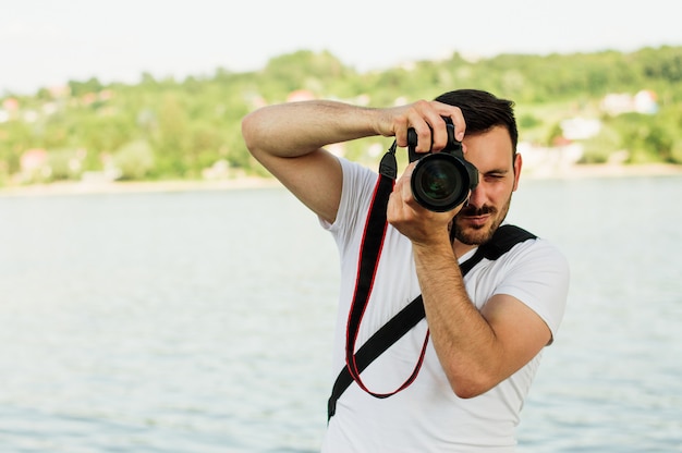 Młody człowiek fotograf robienia zdjęć z jego DSLR