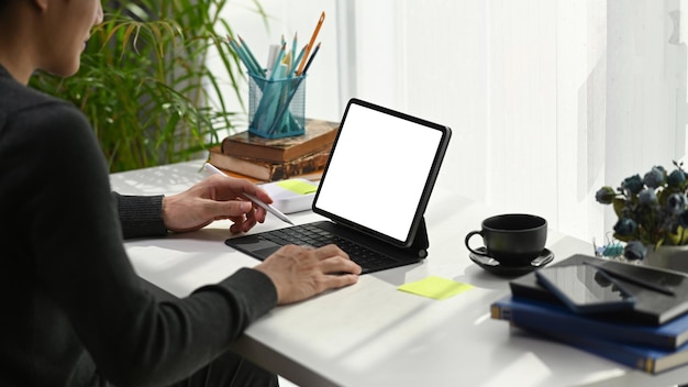 Młody człowiek freelancer trzymający rysik i pracy na tablecie komputerowym w wygodnym miejscu pracy.