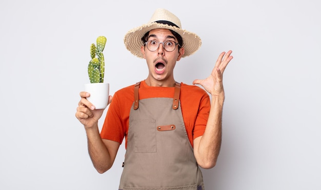 Młody Człowiek Hiszpanin Krzyczy Z Rękami W Powietrzu. Ogrodnik Z Koncepcją Kaktusa