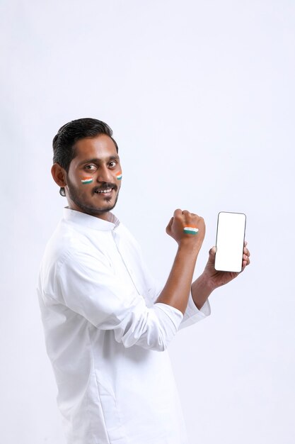 Młody człowiek indian obchodzi Dzień Niepodległości i pokazuje smartphone.
