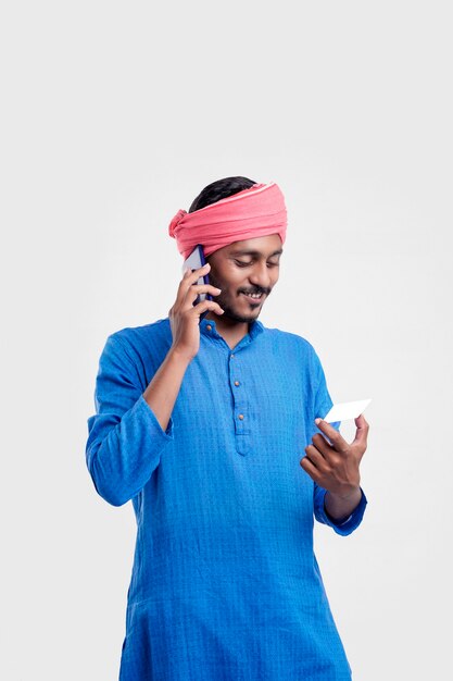 Młody człowiek indyjski w tradycyjnym nosić i rozmawiając na smartfonie i za pomocą karty na białym tle.