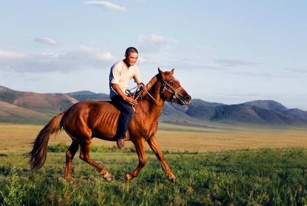 Młody człowiek jedzie konia w Mongolia