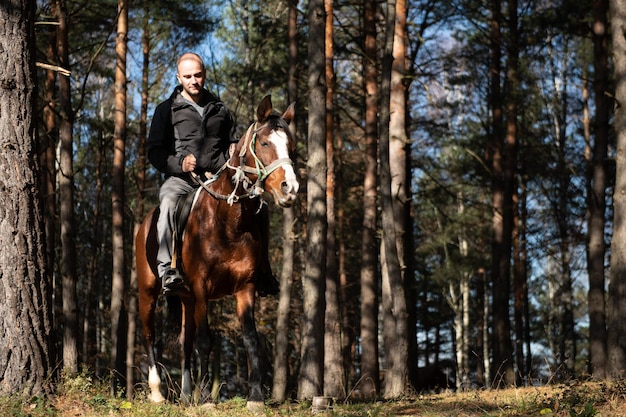 Młody człowiek jedzie na koniu