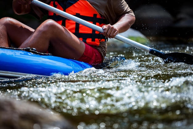 Zdjęcie młody człowiek jest rafting w rzece.