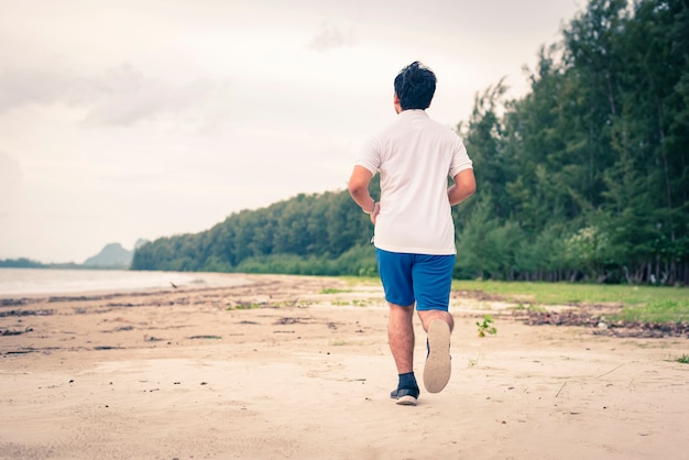 Młody człowiek jogging na plaży