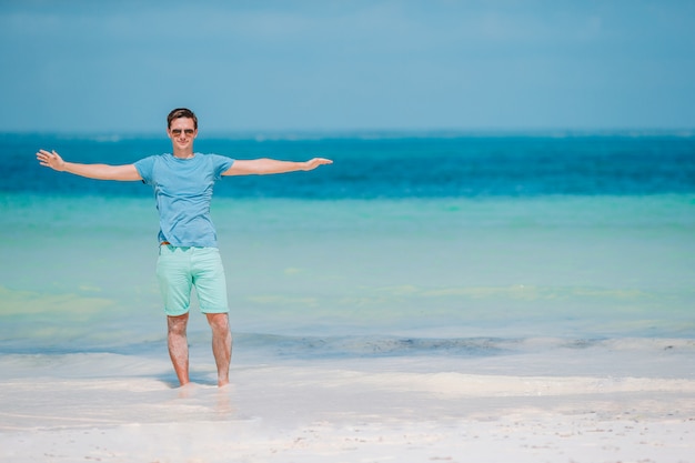 Młody człowiek na białej tropikalnej plaży