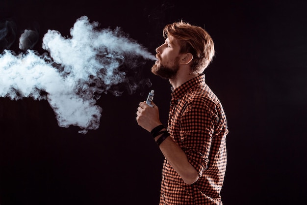 Młody człowiek palący elektroniczny papieros