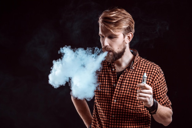 Zdjęcie młody człowiek palący elektroniczny papieros