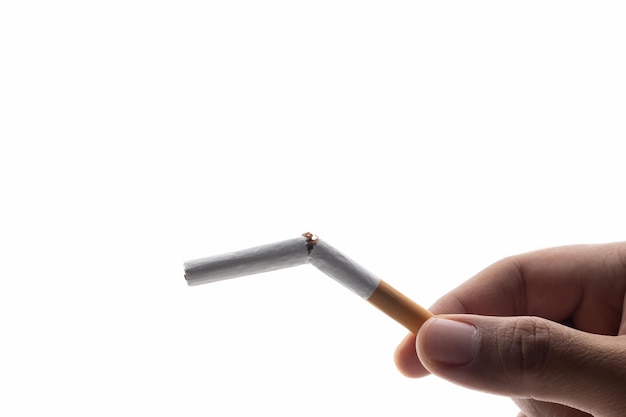 Młody człowiek ręką przełamał papierosa na pół. Chce rzucić palenie dla dobrego zdrowia. światowy dzień tytoniu.