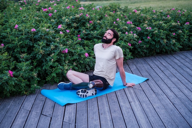 Młody człowiek relaksujący się po uprawianiu jogi na świeżym powietrzu o zachodzie słońca