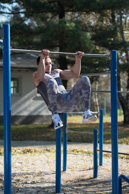 Młody człowiek robi ćwiczenia crossfit z dips barem w parku miejskim szkolenia i ćwiczenia na wytrzymałość zdrowego stylu życia koncepcja na świeżym powietrzu