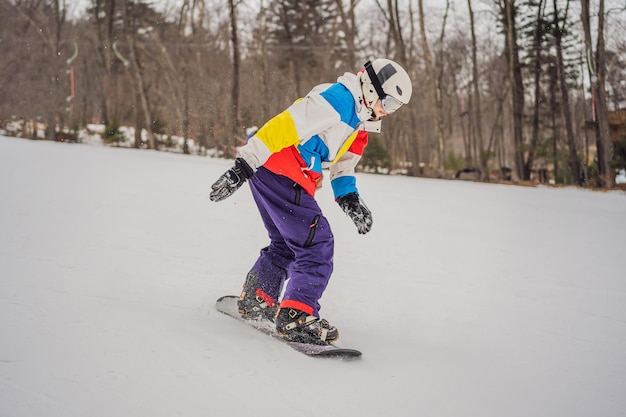 Młody człowiek skacze z snowboardem w górach