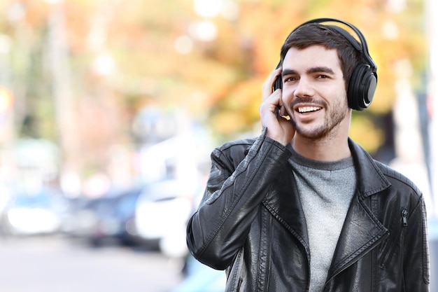 Młody człowiek słuchający muzyki i spacerujący ulicą
