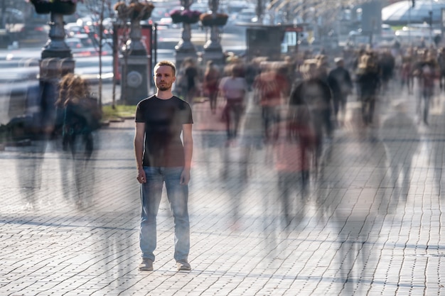 Zdjęcie młody człowiek stoi na środku zatłoczonej ulicy
