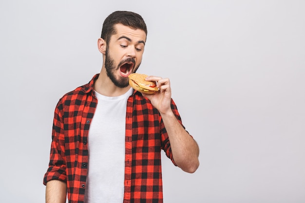 Młody Człowiek Trzyma Kawałek Hamburger. Pojęcie Diety Na Białym Tle.