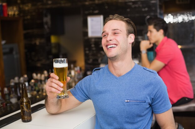 Młody człowiek trzyma kufel piwa