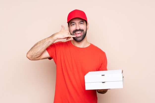 Młody człowiek trzyma pizzę robi telefonu gestowi. Zadzwoń do mnie znak