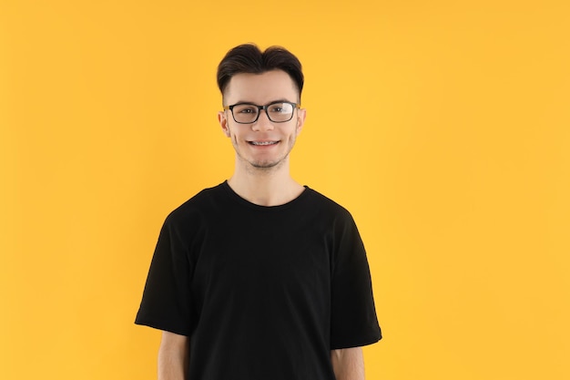 Młody człowiek w okularach na żółtym tle