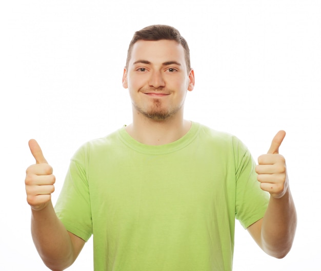 Młody człowiek w zielonej koszuli pokazując kciuk do góry.
